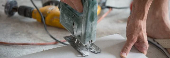 Person schneidet Rigipsplatte mit Stichsäge